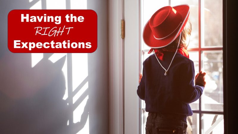 Girl wearing cowboy hat looking out the window