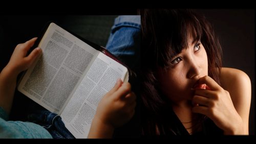 Brunette woman with a questioning look next to an open Bible