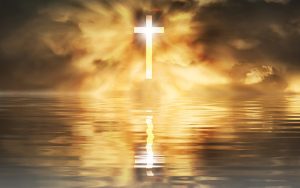 Refection of a cross over water during a golden sunset